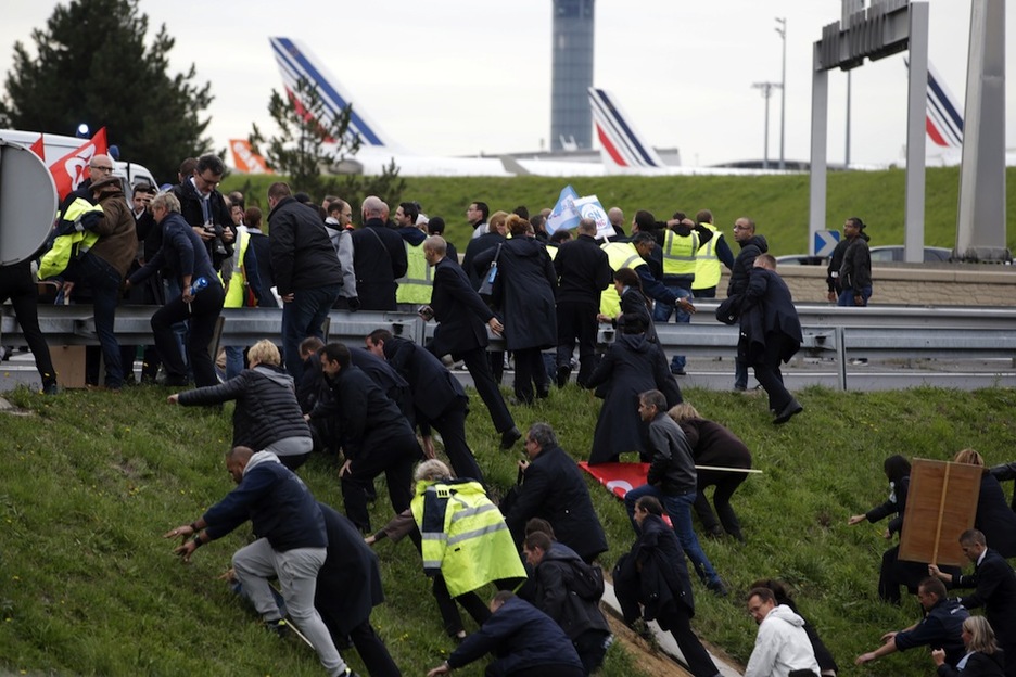 Los trabajadores de Air France escapan de la Policía. (Kenzo TRIBOUILLARD/AFP)