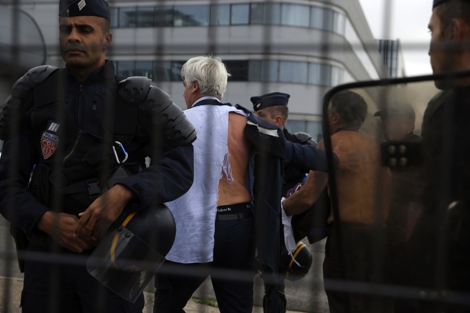 El director de espaldas, con la camisa y chaquetra destrozadas. (Kenzo TRIBOUILLARD/AFP)