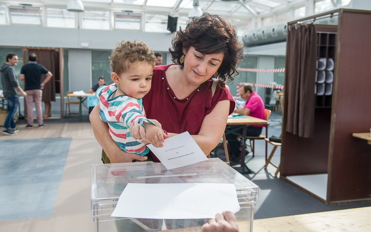 Una mujer se dispone a depositar el voto con la ayuda de su hijo. (ARGAZKI PRESS)