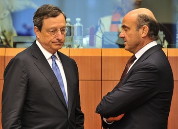 El ministro español de Economía, Luis de Guindos, charla con Mario Draghi, presidente del BCE. (Georges GOBET/AFP PHOTO)