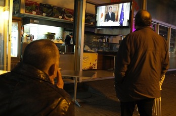Vecinos de Nicosia siguen en un café el discurso televisado del presidente, este lunes por la tarde. (Yiannis KOURTOGLOU/AFP PHOTO)