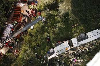 El autobús, a la derecha, destrozado tras el accidente, que ha dejado más de una treintena de muertos. (AFP)