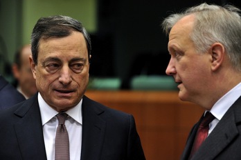 Mario Draghi conversa con Olli Rehn durante el transcurso de la reunión del Eurogrupo. (Georges GOBET/AFP)