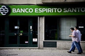 Dos personas pasan ante un local del Banco Espirito Santo. (Patricia DE MELO MOREIRA/AFP PHOTO)