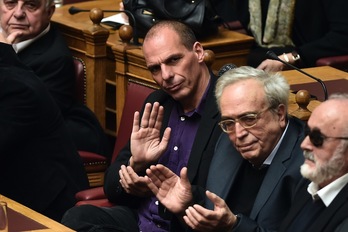 El ministro de Finanzas, Yanis Varufakis, aplaude la intervención de Tispras en el Parlamento. (Aris MESSINIS/AFP) 