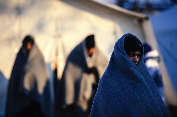 Refugiados se protegen del frío con mantas. (Dimitar DILKOFF / AFP)