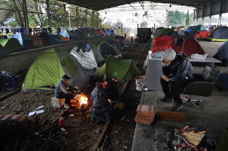 Estos refugiados han encontrado un lugar en el que resguardarse de la lluvia en esta antigua estación de tren en Idomeni, Grecia. (DANIEL MIHAILESCU / AFP)