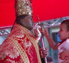 Los más pequeños rodean al santo de flores rojas y blancas 