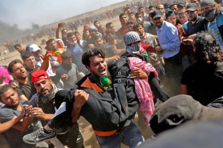 Un palestino traslada a una persona herida por las fuerzas israelíes. (Thomas COEX/AFP)