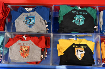 Camisetas representando las cuatro casas del colegio al que acude Harry Potter. (Justin TALLIS / AFP)