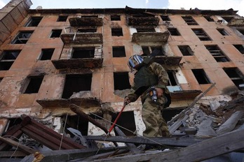Un soldado ruso entre los escombros de un edificio en ruinas en Mariupol.