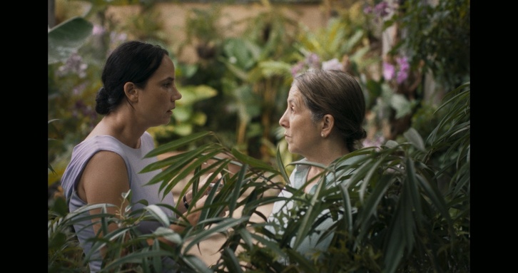 Imagen de la cinta «Querido trópico» en la que Ana María y Mercedes conversan en el jardín tropical de la vivienda.